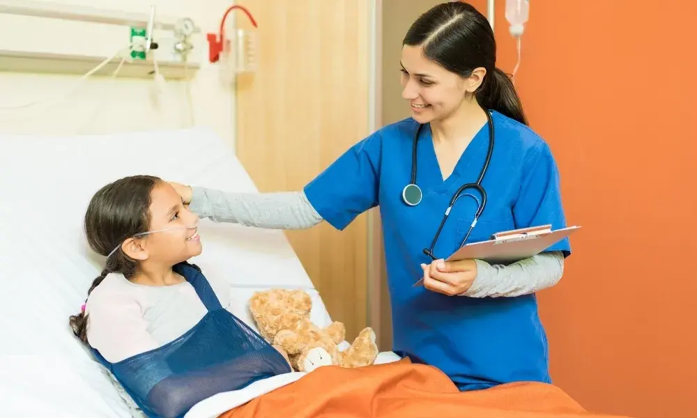 A professional baby care attendant holding a happy baby in a home setting